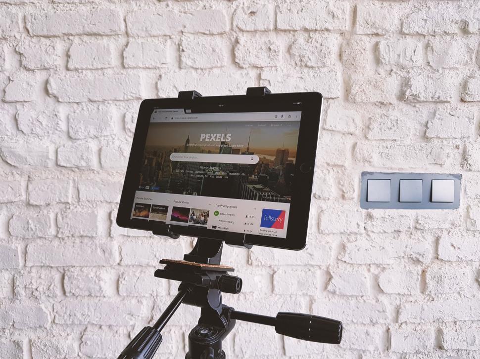 Free Image of Tablet on tripod displaying a stock photo website 