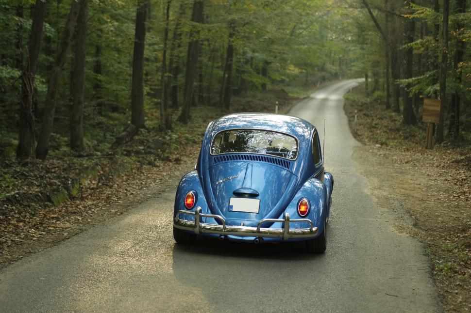 Free Image of Classic blue Volkswagen Beetle on forest road 