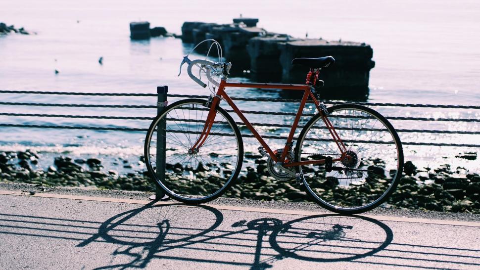 Free Image of Bicycle against coastal backdrop with shadows 