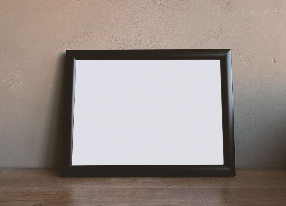 Free Image of Black framed blank canvas on grey wall 