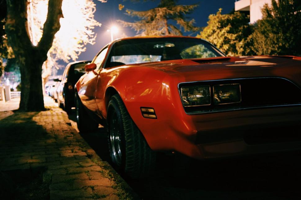Free Image of Red classic muscle car parked at night 