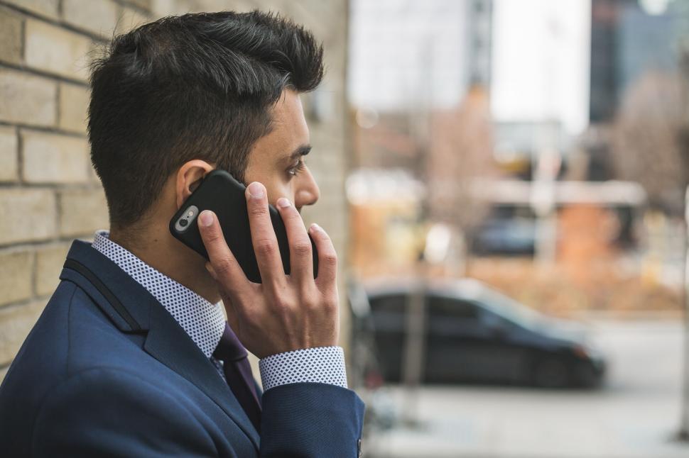 Free Image of Businessman talking on the phone in the city 