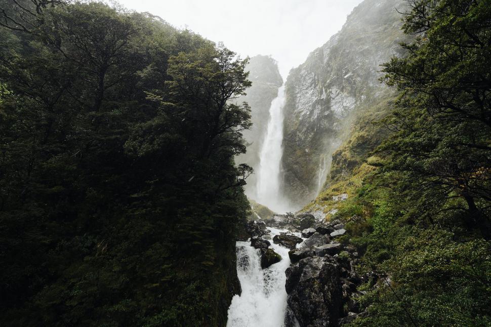 Free Image of Majestic waterfall surrounded by lush greenery 
