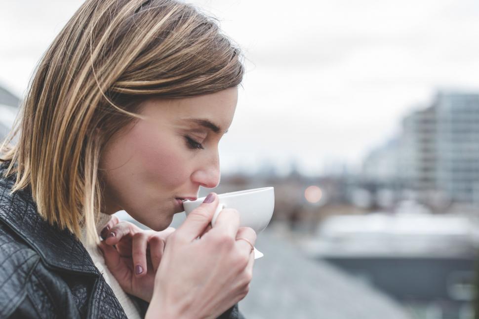 Free Image of Woman enjoying a hot drink on a cool day 