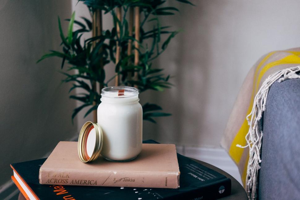 Free Image of Candle on stack of books in cozy room 