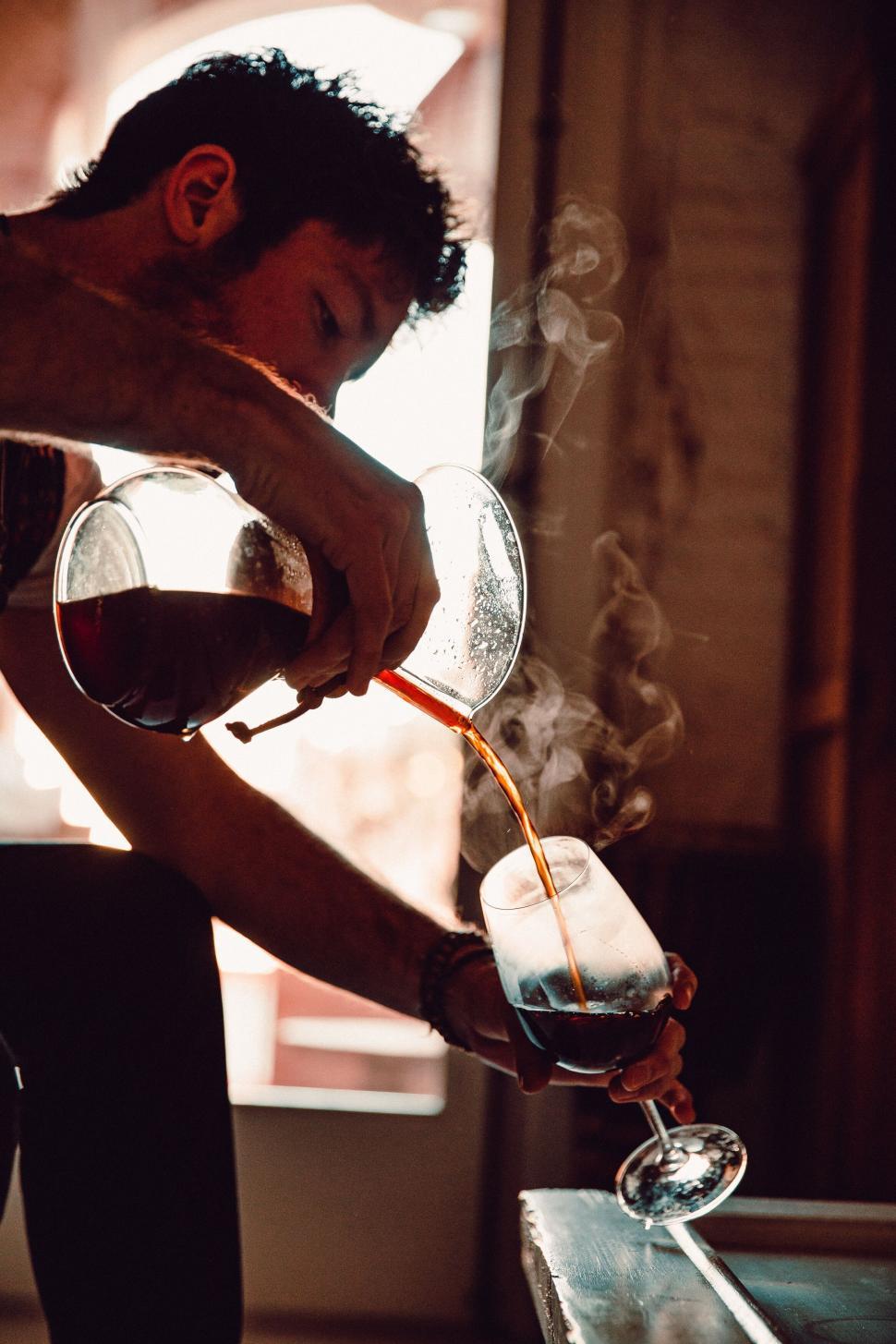 Free Image of Silhouette with steamy drinks in warm light 