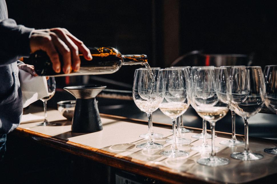 Free Image of Pouring drink into glasses at a bar counter 