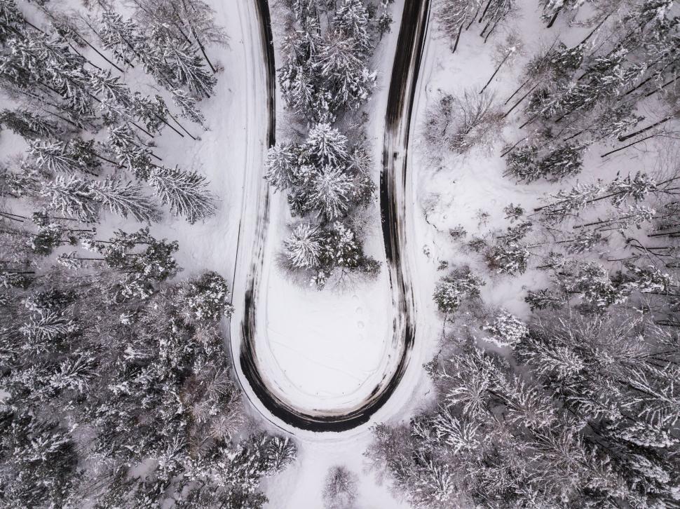 Free Image of Aerial view of snowy forest road bend 