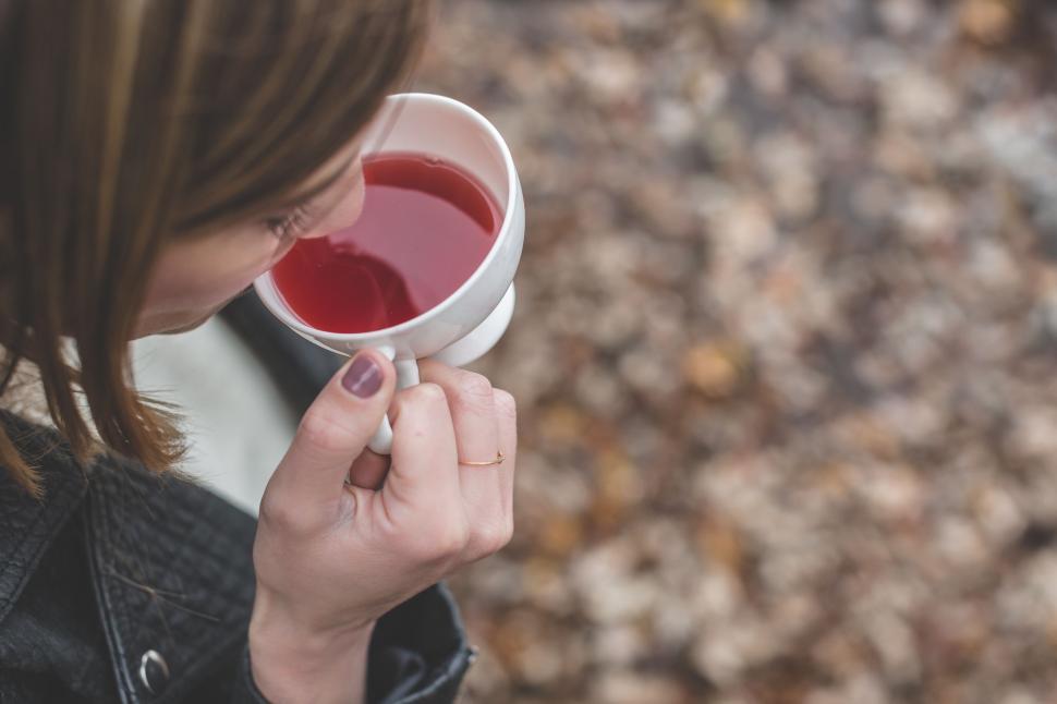Free Image of Close-up of woman sipping tea outdoors 