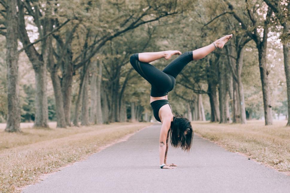 Free Image of Woman practicing handstand on a road 