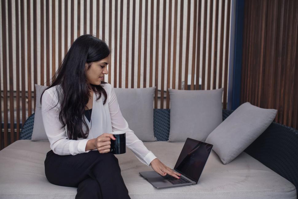 Free Image of Businesswoman working on laptop in office lounge 