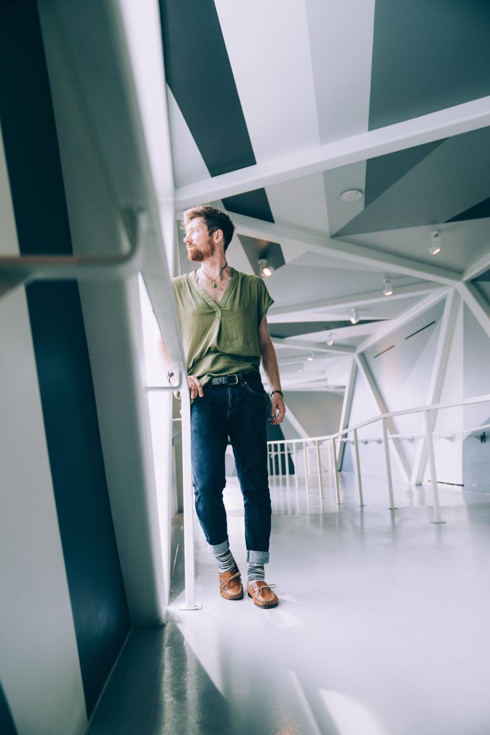 Free Image of Man in casual style posing in modern hall 