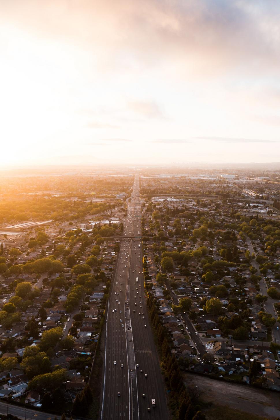 Free Image of Aerial view of sunset over a long road 
