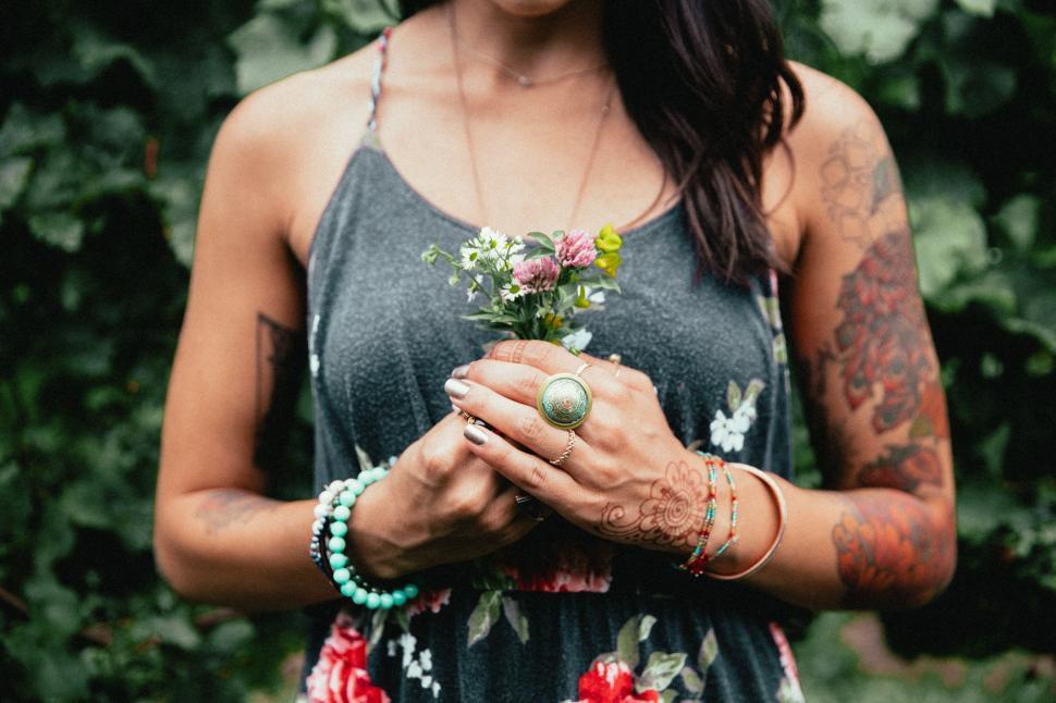 Free Image of Woman holding flowers close to her heart 