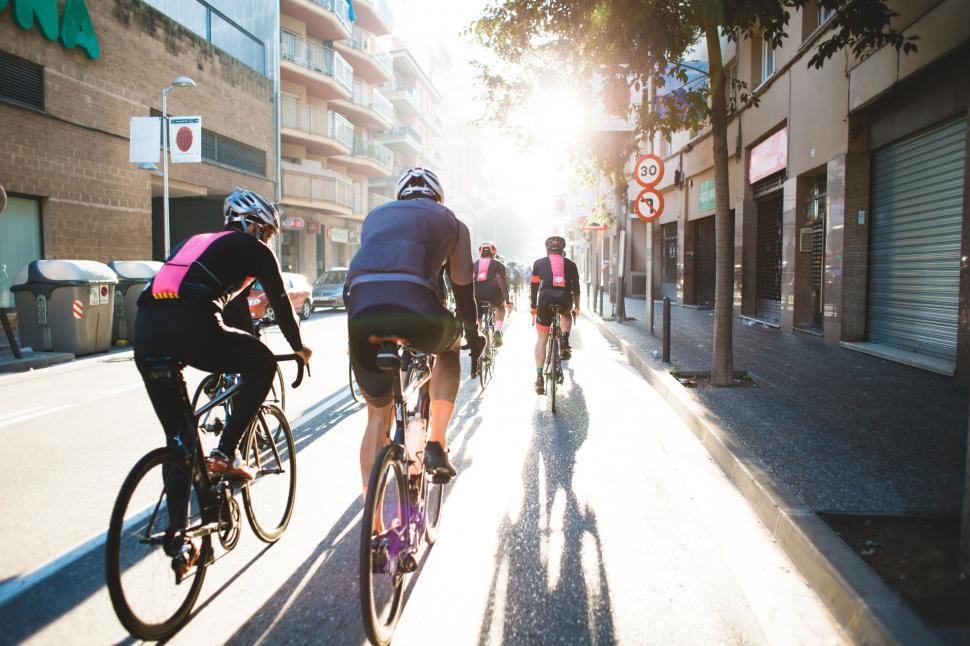 Free Image of Group of cyclists on bright city street 
