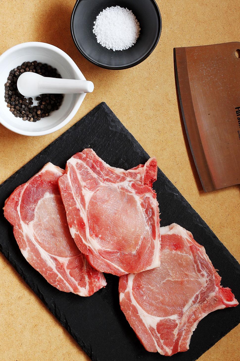 Free Image of Raw pork chops on a kitchen counter 