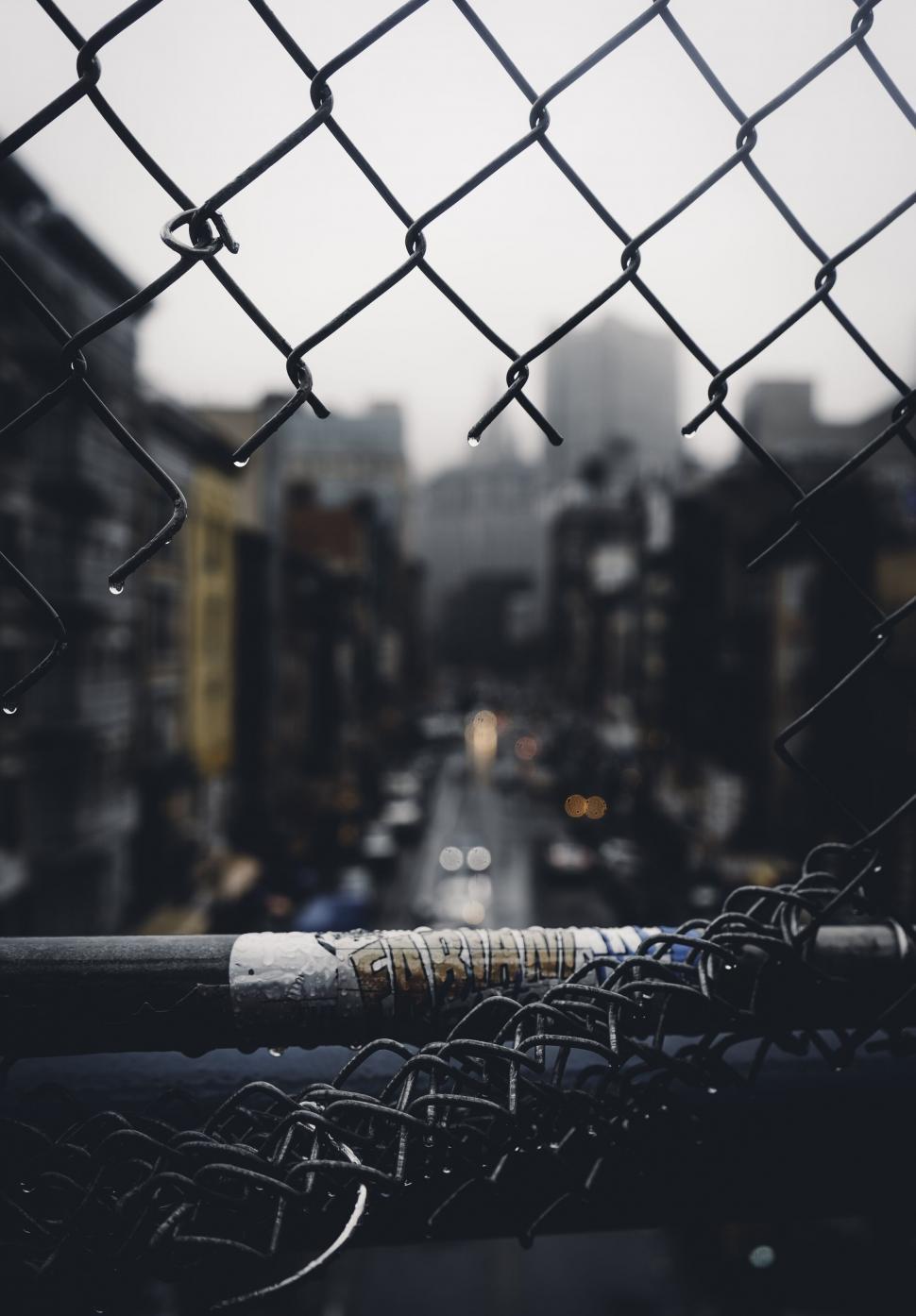 Free Image of Urban view through a chain-link fence 