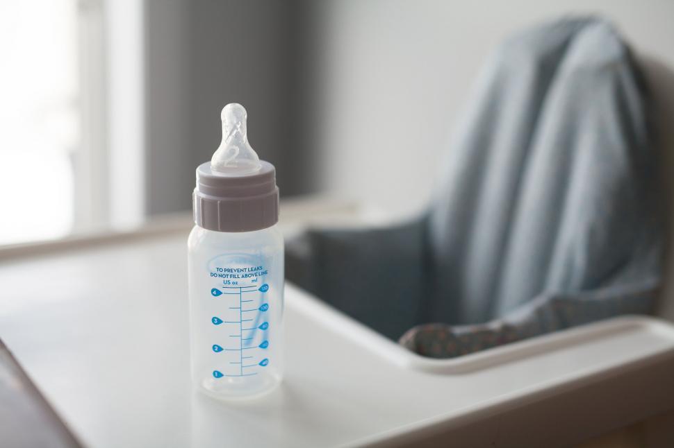 Free Image of Baby bottle on a highchair with measurement marks 