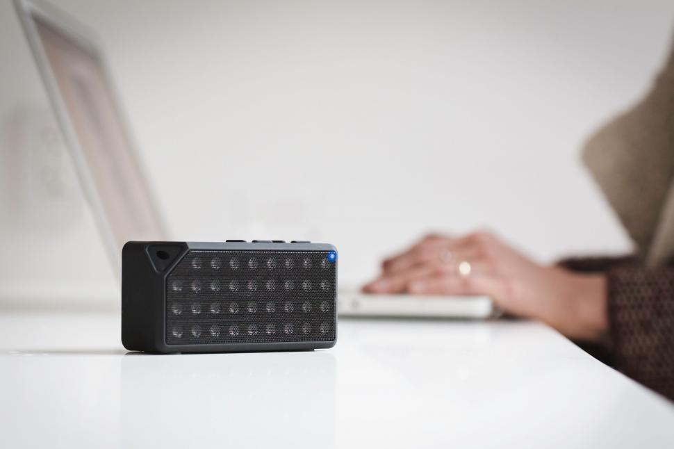 Free Image of Portable speaker on desk with typing hands 