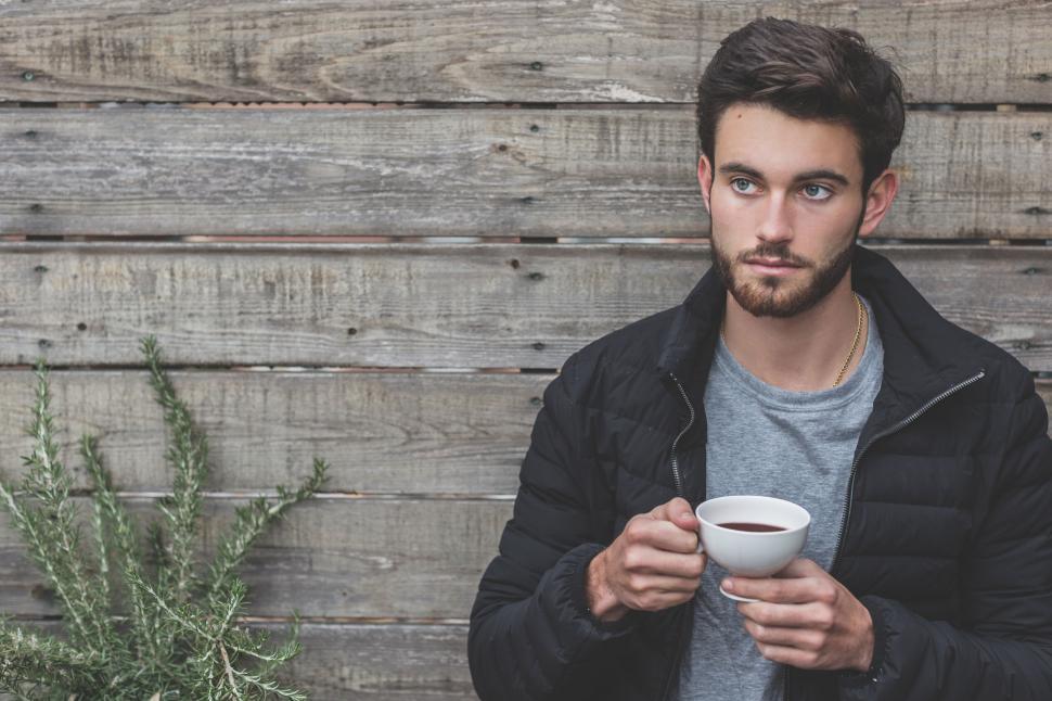 Free Image of Man holding coffee cup outdoors 