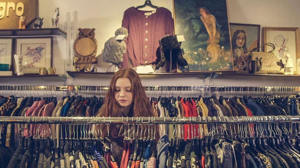 Free Image of Young woman browsing through clothes at store 
