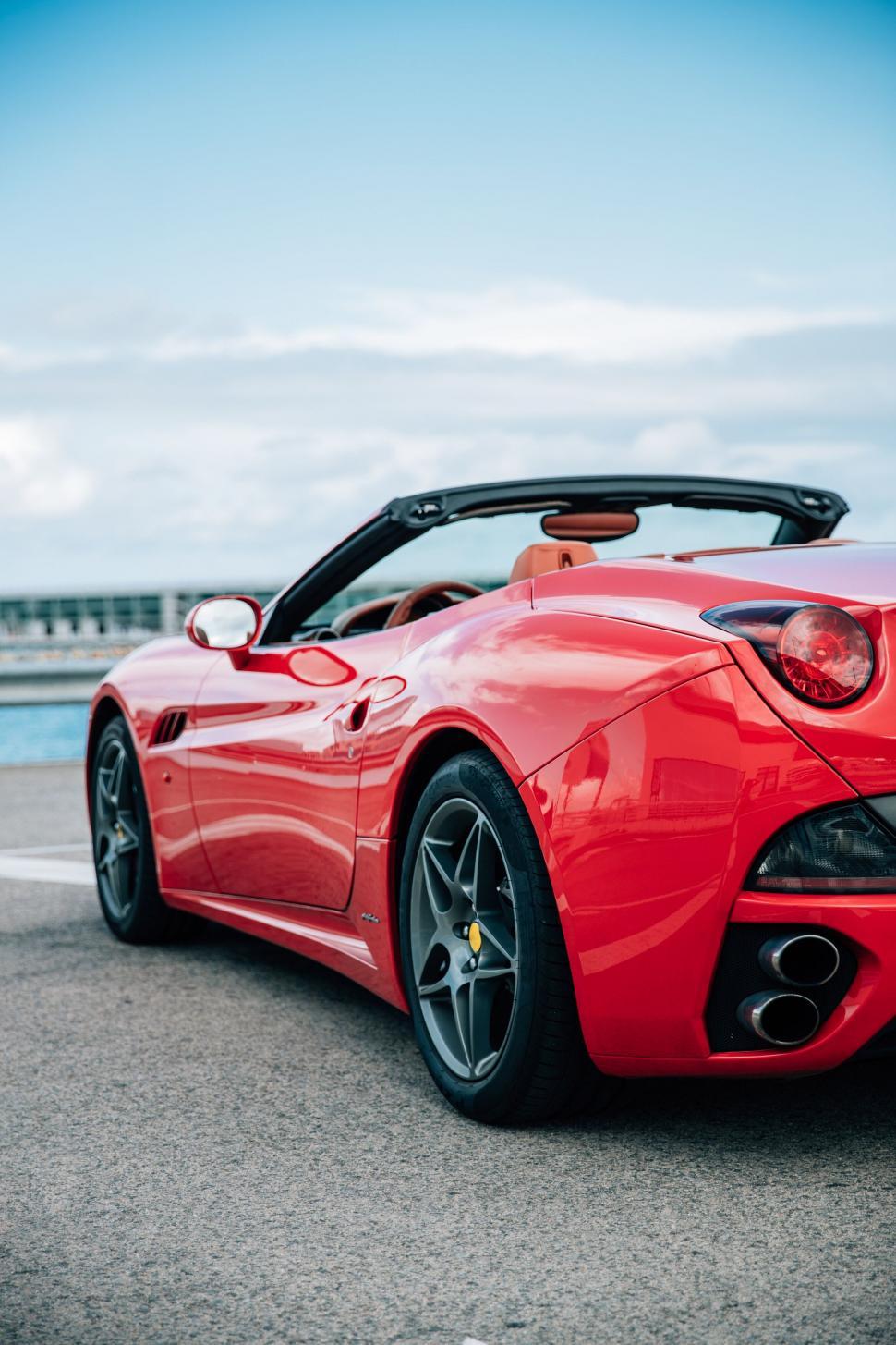 Free Image of Red luxury sports car parked by the sea 
