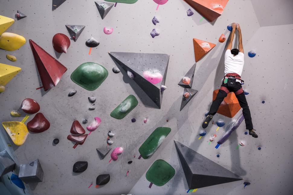Free Image of Climber ascending indoor bouldering wall 