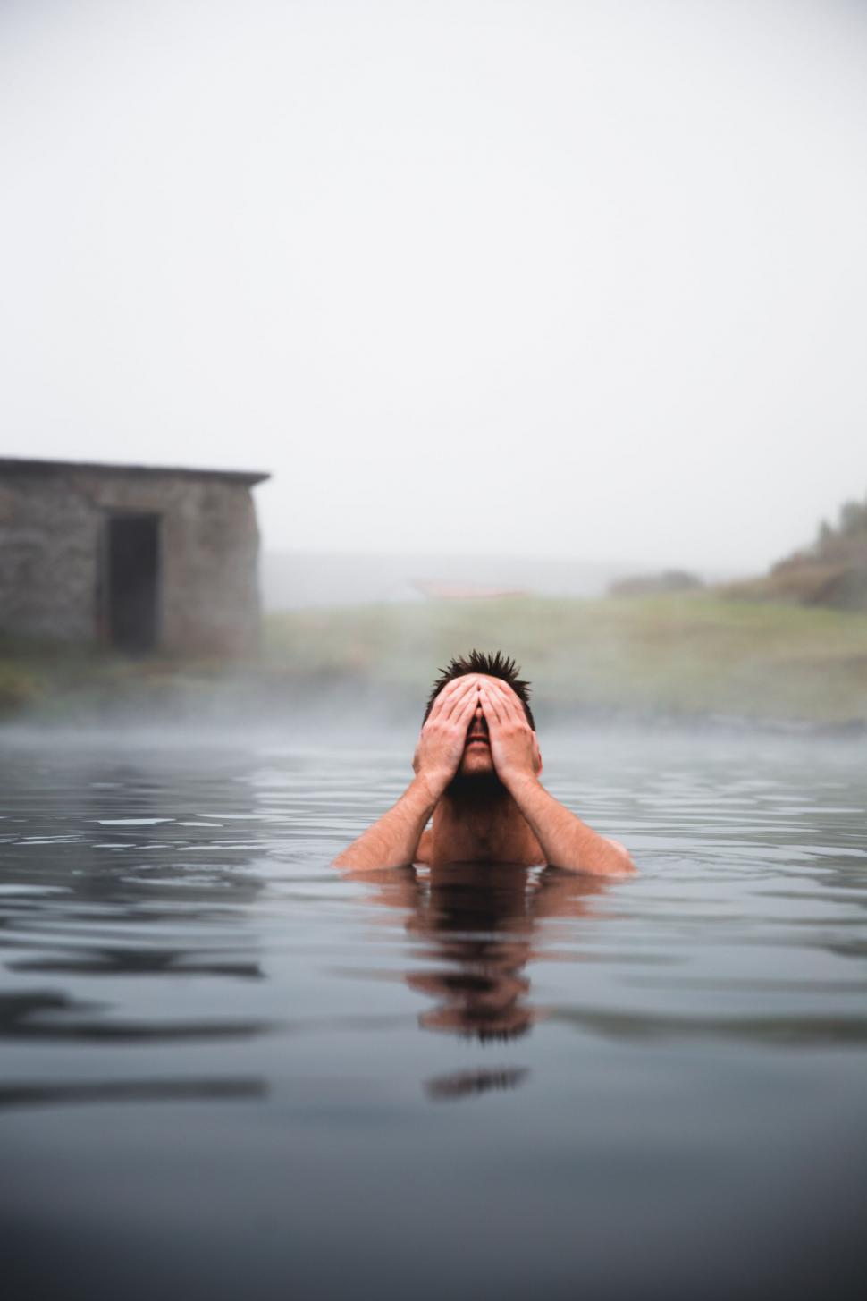 Free Image of Man submerged in water with hands on face 