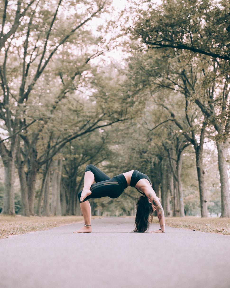 Free Image of Woman practicing yoga in a serene park 