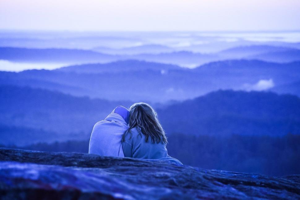 Free Image of Couple enjoying a serene mountain view at dusk 