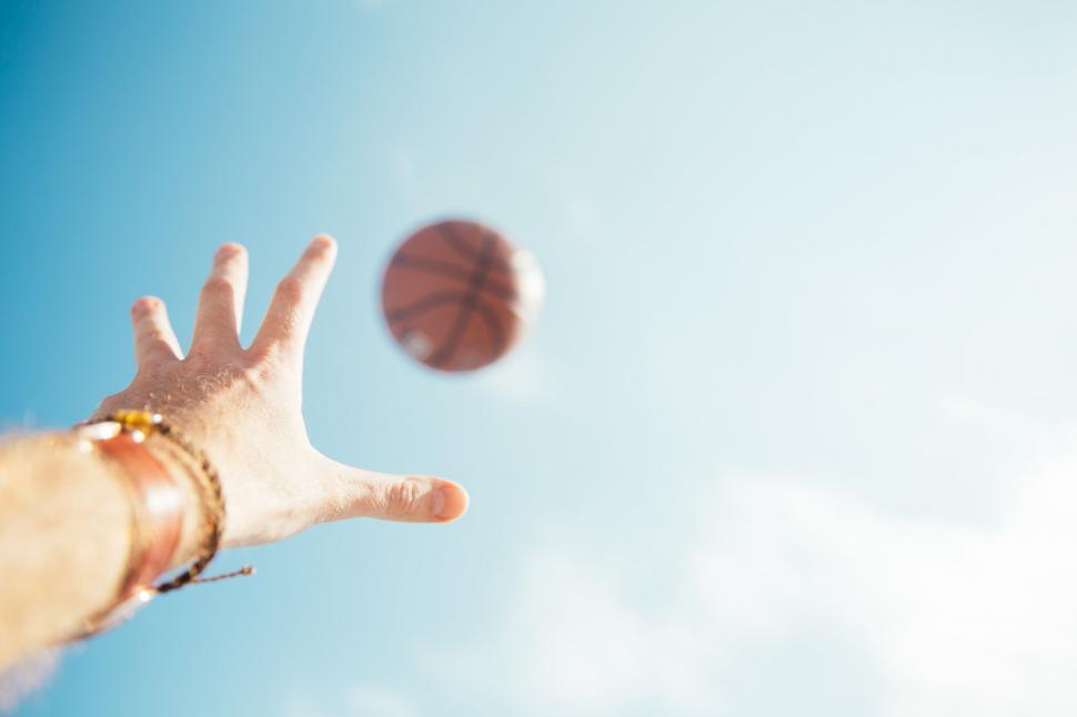 Free Image of Hand reaching for a football in the sky 