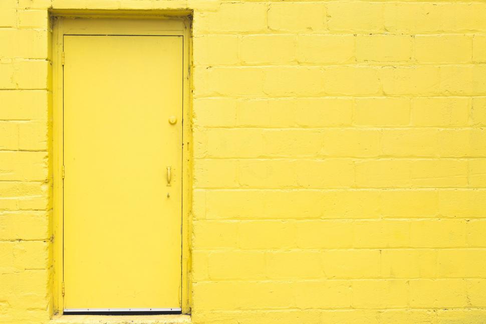 Free Image of Vibrant yellow door on brick wall 