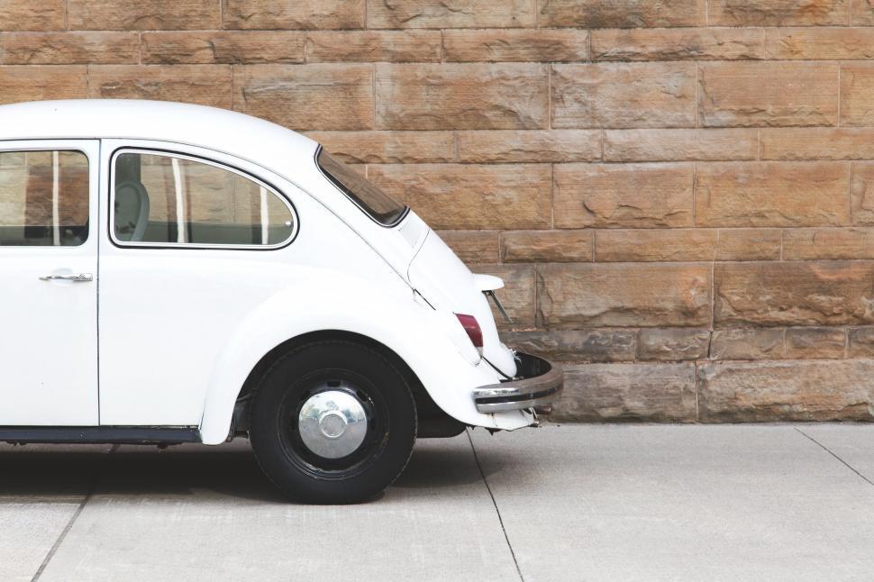Free Image of Vintage white car against stone wall 