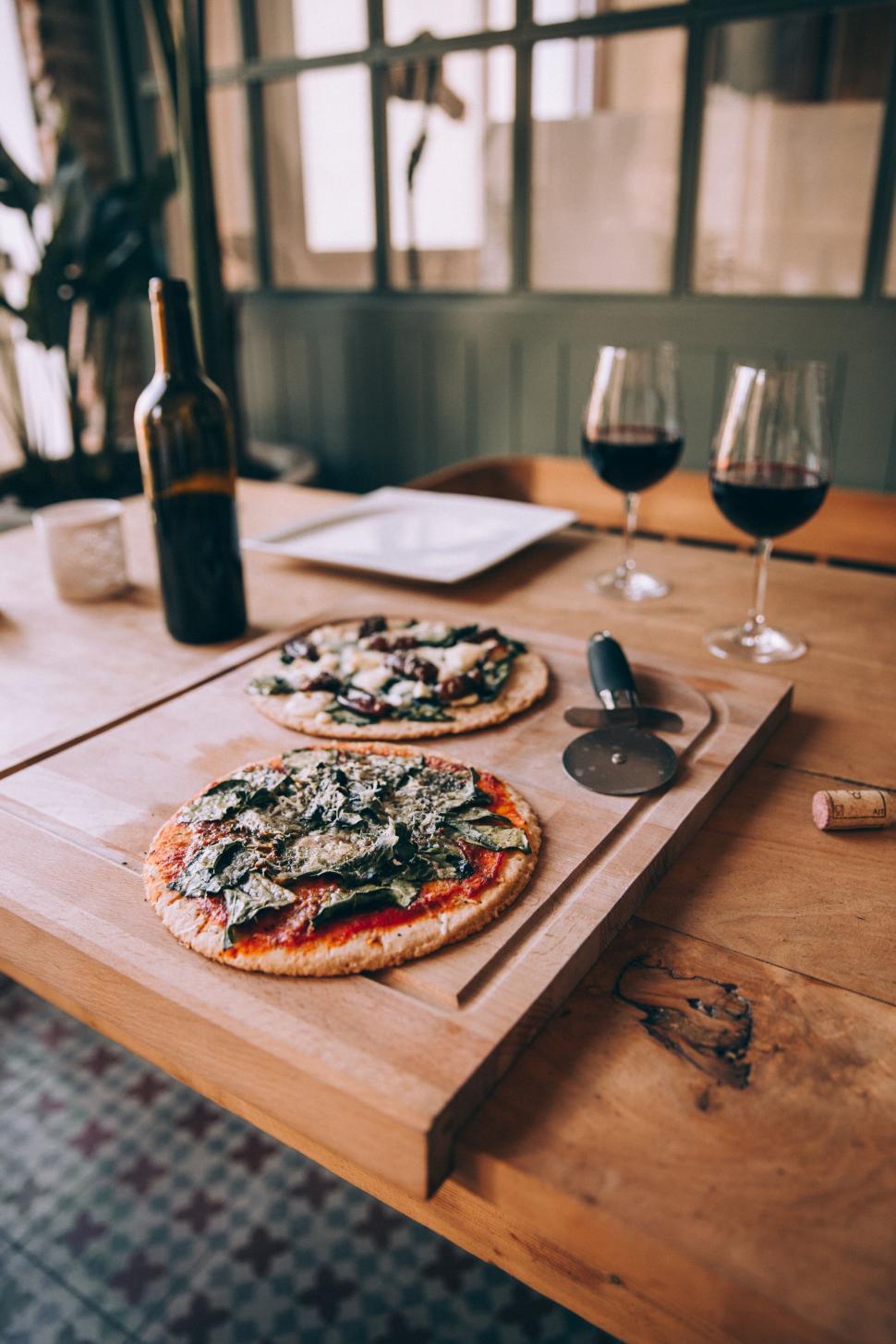 Free Image of Rustic pizza and wine on wooden table 