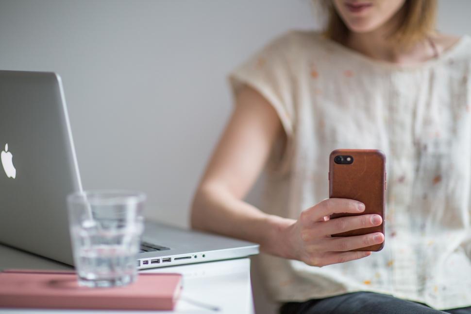 Free Image of Casual woman using smartphone at her desk 