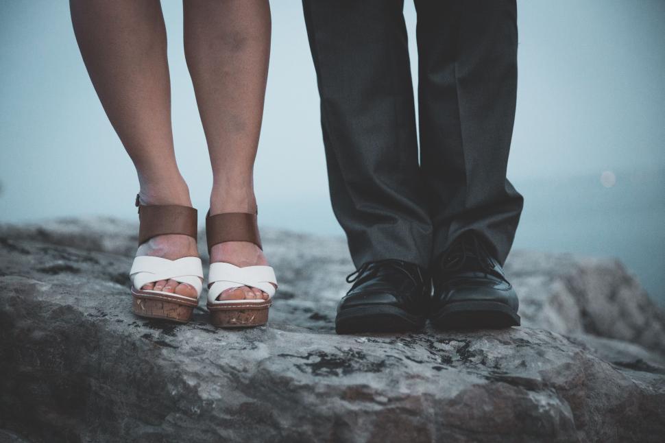 Free Image of Couple s feet on rock overlooking water 