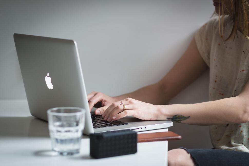 Free Image of Woman typing on laptop in a minimalist setup 