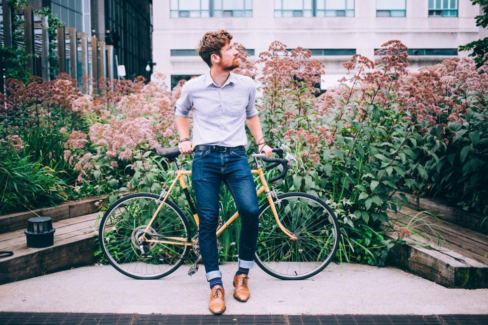Free Image of Man holding bicycle in urban garden 