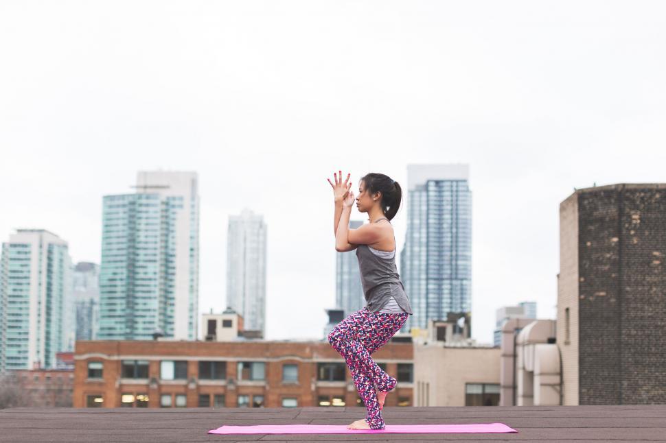 Free Image of Woman practicing yoga on a rooftop 