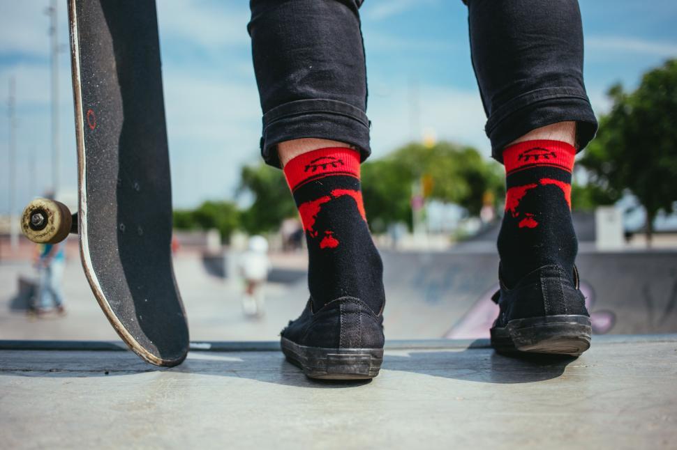 Free Image of Skateboarder s feet with red dinosaur socks 