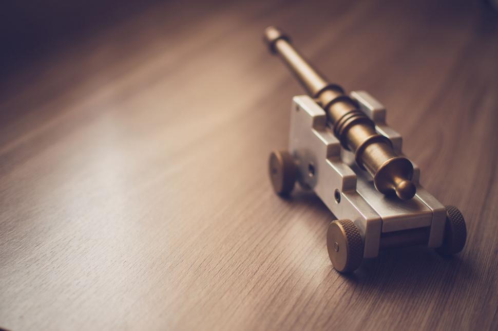 Free Image of Vintage Naval Cannon Model on Wooden Surface 