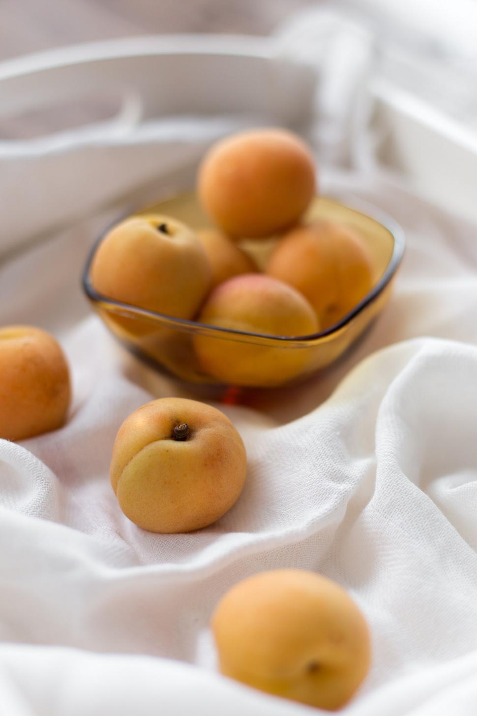 Free Image of Fresh apricots in a glass bowl on fabric 