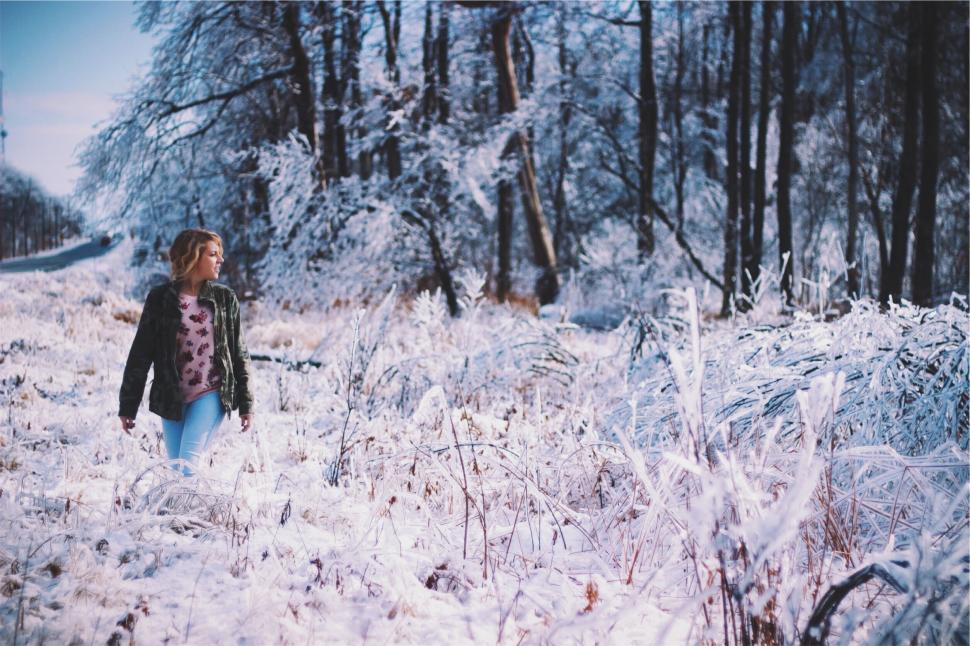 Free Image of Woman walking through snowy forest 