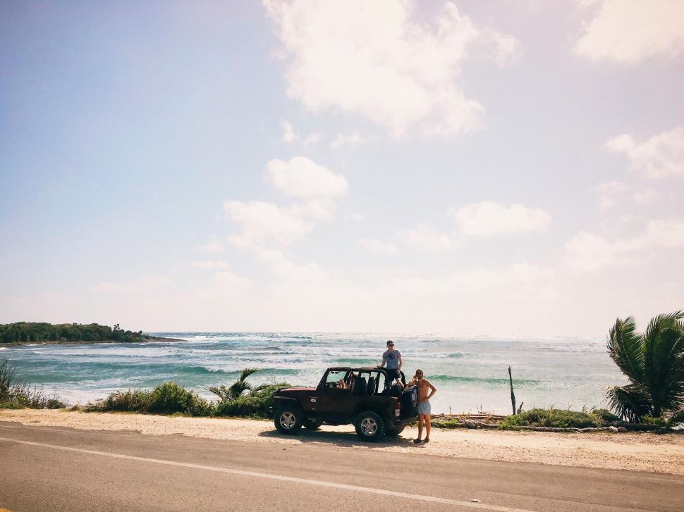Free Image of Couple with Jeep on a coastal road trip 