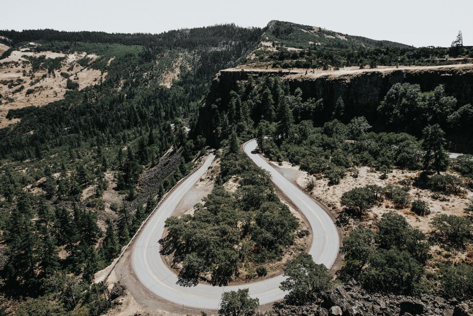 Free Image of Curving road in a lush mountainous area 
