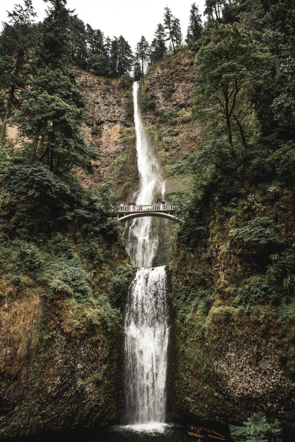 Free Image of Majestic multi-tiered waterfall with a bridge 