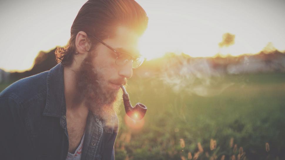 Free Image of Man with a pipe blocked face in sunset 