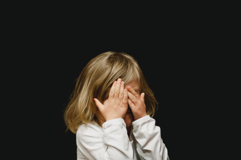 Free Image of Child covering face with hands in fear 