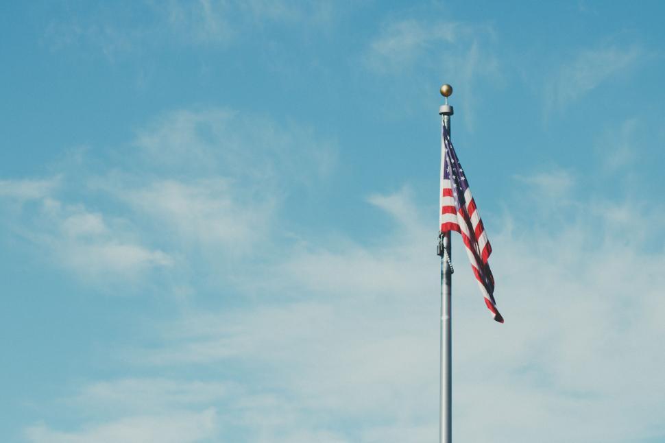 Free Image of American flag waving under a clear blue sky 