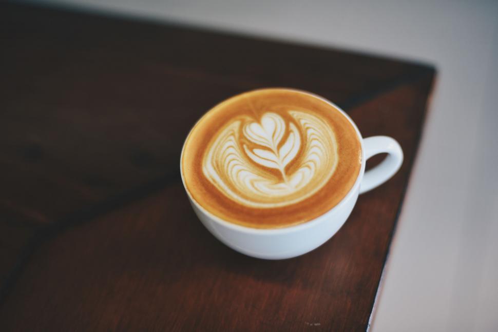 Free Image of Cup of coffee with latte art on wooden table 